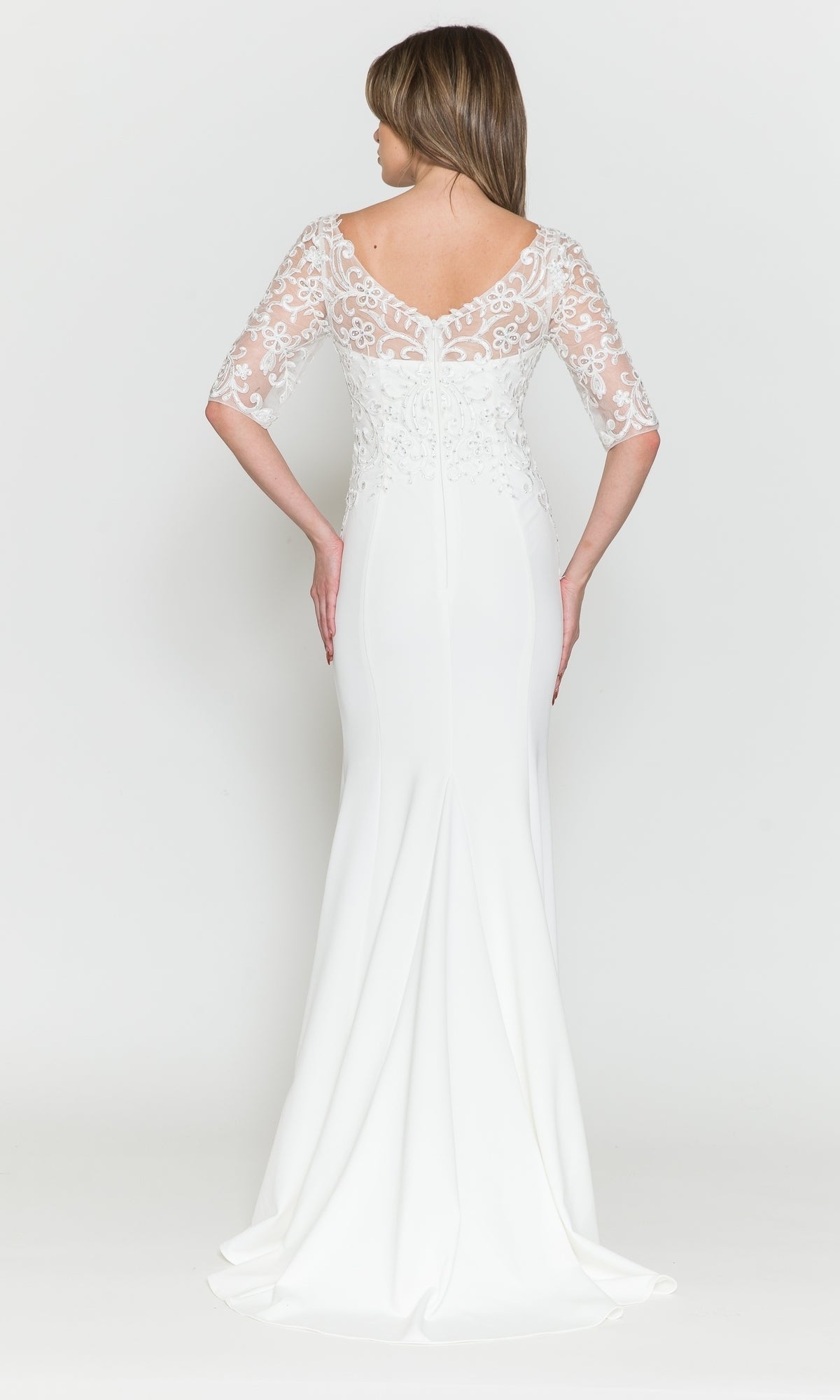 A woman wears the Embroidered Sheer-Sleeved Formal Prom Dress 8560, a floor-length white gown with lace half sleeves and a floral lace bodice, shown from the back against a plain background.
